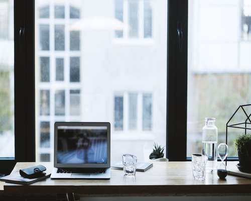 Organized work desk with water and natural light